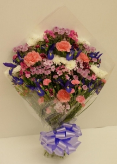 Funeral Flowers in Cellophane - Funeral sheaf of flowers open wrapped in cellophane with a lilac or purple bow, Colours to suit a Lady or Man. Item shown to suit a lady, please specify ( this is not a gift item and is not suitable as a gift) Our experienced Birmingham florists create this Funeral Flowers in Cellophane with a respectful finish suitable for a funeral, commemoration or celebration of life. Every section is constructed with attention to symmetry, visual depth and neat edging, helping the tribute look considere...