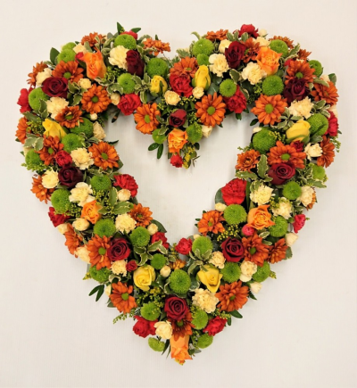 Loose Open Heart - This open heart tribute is a lovely selection of autumn coloured flowers in shades of reds, oranges, golds, yellows and greens including small headed roses, spray carnations, chrysanthemums and solidaster. Available in two sizes. Standard: Approx 40cm x 40cm, Deluxe: 50cm x 50cm (shown) This Loose Open Heart is carefully handcrafted in Birmingham for a meaningful farewell, memorial gathering or funeral service. The florists consider proportion, outline, colour balance and texture so the fini...