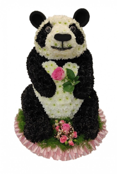 Panda funeral tribute - This hand carved bespoke tribute is massed in double chrysanthemums and sprayed with flower paint the spray and flower and ribbon can be customised. The 3D tribute stands approximately 75cm (30in) tall by approx 45cm (18in) wide This Panda funeral tribute is carefully handcrafted in Birmingham for a meaningful farewell, memorial gathering or funeral service. The florists consider proportion, outline, colour balance and texture so the finished design has a dignified, carefully arranged appear...