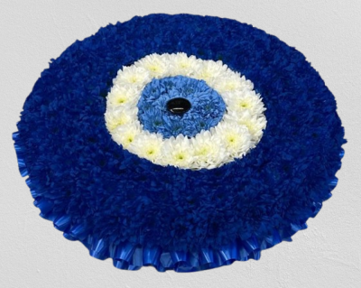 Turkish Magic Eye - This magic eye funeral tribute is created using a 21 posy pad using sprayed chrysanthemums. Handcrafted by Buttercups & Daisies Florist Birmingham, this Magic Eye is prepared as a thoughtful floral tribute for a funeral, memorial or remembrance service. Shape, scale, contrasting tones and finishing details are assessed closely to create an appropriate and respectful presentation. Seasonal availability can affect individual stems, but the florist will protect the designs principal colours, pr...
