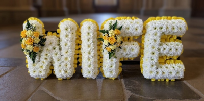 Wife funeral tribute - Wife funeral tribute. A double row of ribbon (choose colour) massed in white chrysanthemums with a sprays of flowers all lettering is fully customisable Handcrafted by Buttercups & Daisies Florist Birmingham, this Wife funeral tribute is prepared as a thoughtful floral tribute for a funeral, memorial or remembrance service. Shape, scale, contrasting tones and finishing details are assessed closely to create an appropriate and respectful presentation. Seasonal availability can affect individu...